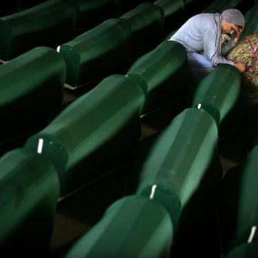 Two Bosnian Muslim women cry over a coffin July 10, 2005 with remains of their relative in a factory hall in Potocari where 610 victims of Srebrenica massacre wait for the funeral.