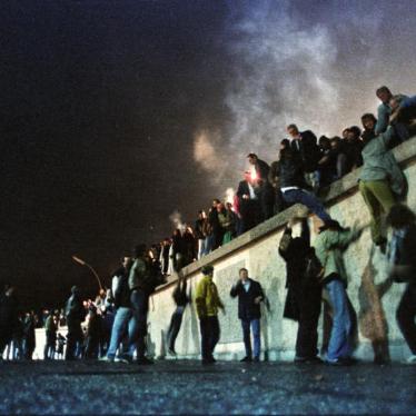 East German citizens climb the Berlin Wall at the Brandenburg Gate after the opening of the border was announced early on November 9, 1989. 