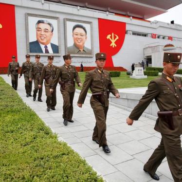 Soldiers walk under pictures of former North Korean leaders Kim Il Sung and Kim Jong Il at the capital's main ceremonial square after a mass rally and parade on May 10, 2016.