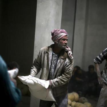 Men store bags of flour unloaded from a Red Crescent aid convoy in the rebel-held, besieged town of Jesreen in Eastern Ghouta, Syria on March 7, 2016. 