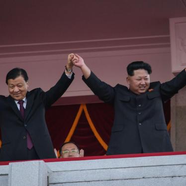 North Korea's leader Kim Jong-Un (R) and Chinese Politburo standing committee member Liu Yunshan (L) wave from a balcony towards participants of a mass military parade at Kim Il-Sung square in Pyongyang on October 10, 2015