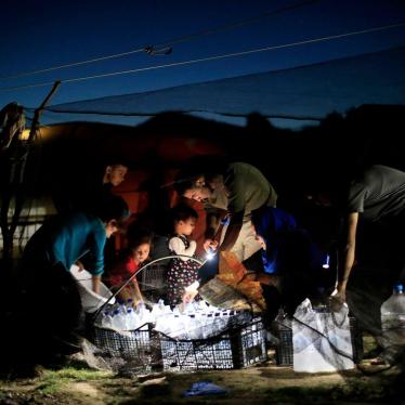 Asylum seekers outside their tent in the "Olive Grove", a makeshift camp outside Moria camp on the island of Lesbos on October 31, 2018.