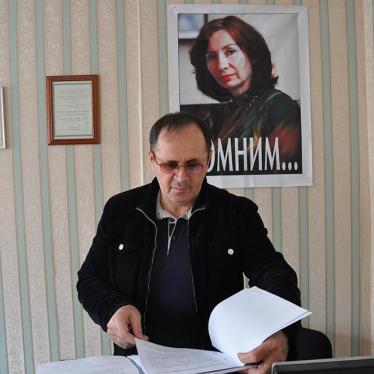 Oyub Titiev stands in front of a portrait of his murdered colleague, Natalia Estemirova, in Memorial's Grozny office, Grozny, Chechnya, Russia. 