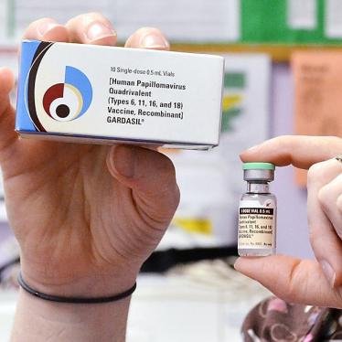 A child health nurse holds up a vial and box for the HPV vaccine, brand name Gardasil